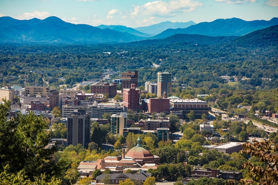 low aerial view of downtown Ashevill, North Carolina and mountains