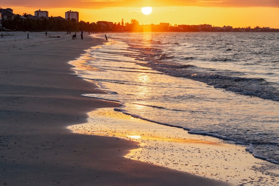The sun coming up over Ft Myers Beach, Florida and reflecting in the waves along the beach.